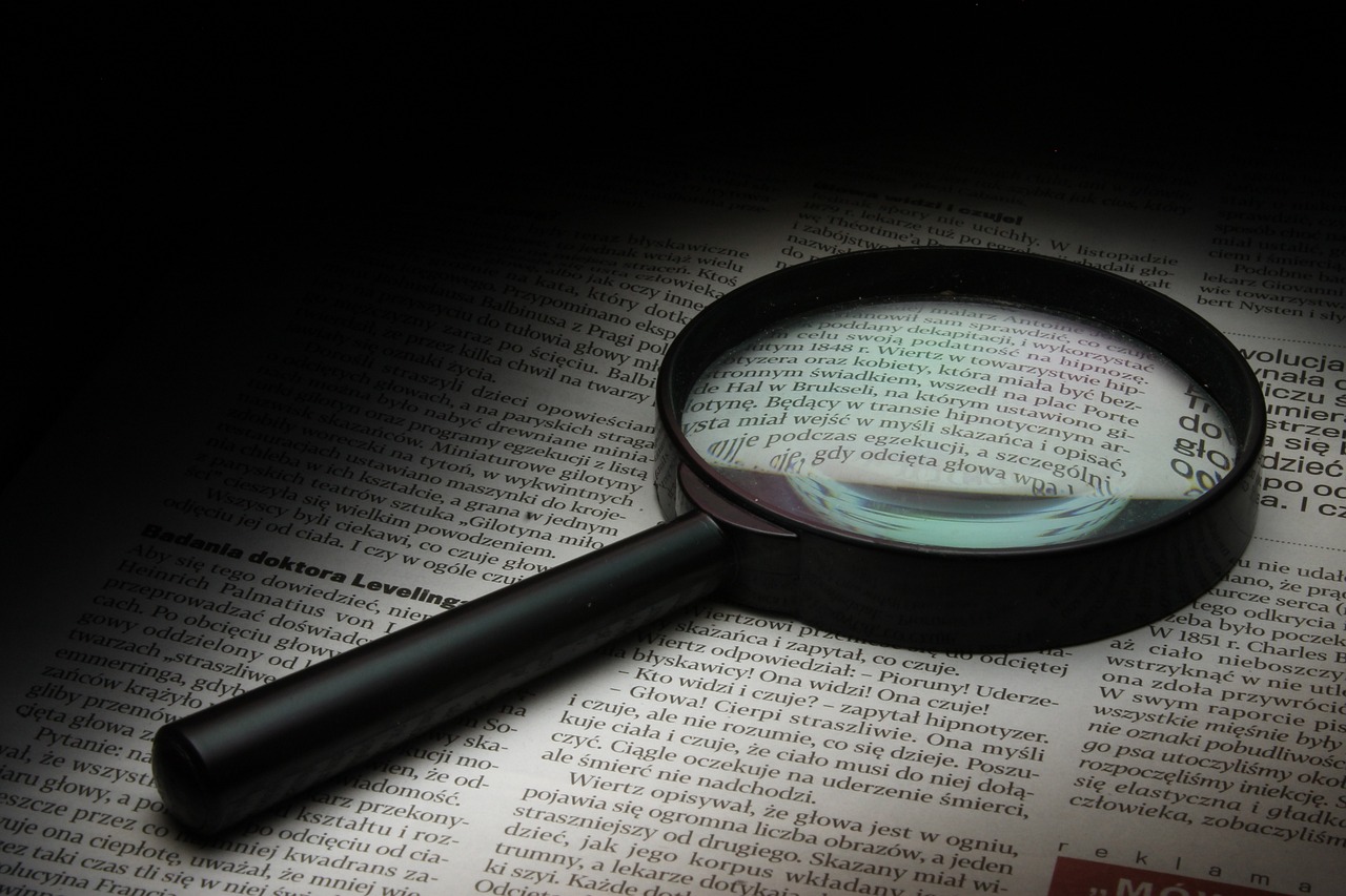 a magnifying glass sitting on top of an open book, journalistic photograph, screengrab, spotlighting, word