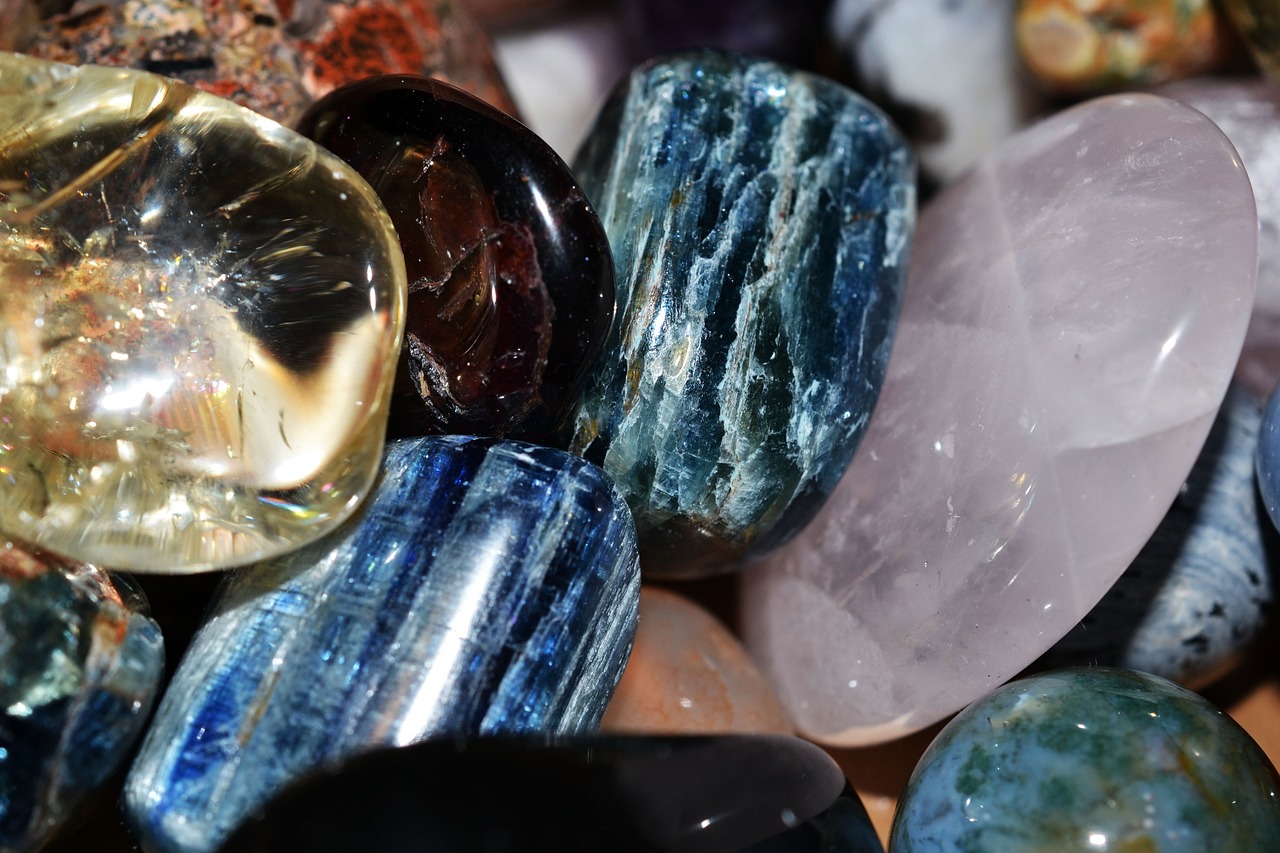 a pile of stones sitting on top of a table, a macro photograph, by Terese Nielsen, pexels, crystal cubism, the blue whale crystal texture, closeup of arms, embedded with gemstones, varied colors