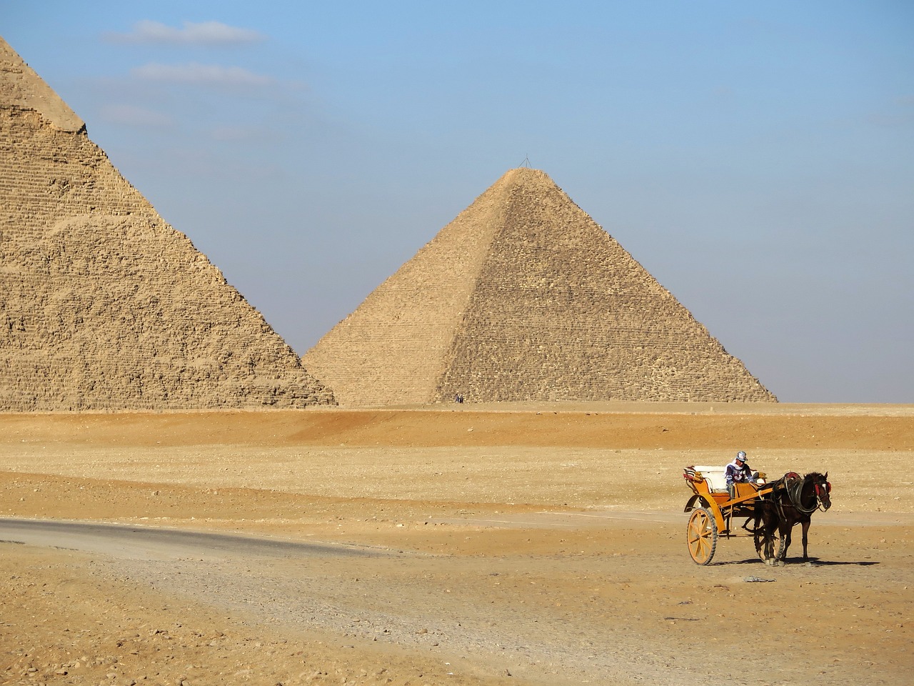 a horse drawn carriage in front of three pyramids, pexels, plein air, ancient megastructure pyramid, 1128x191 resolution, sense of scale, wideshot