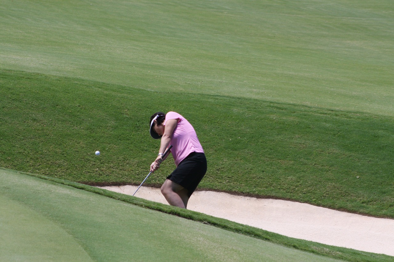 a woman in a pink shirt playing a game of golf, flickr, cobra, sand, hollow, very sharp photo, thailand