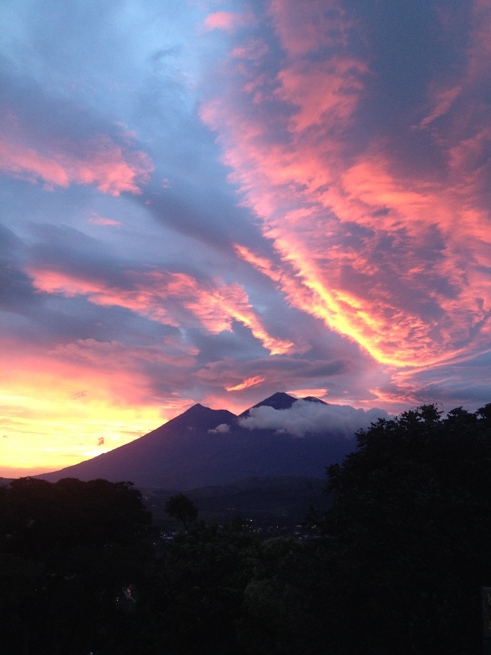 a picture of a sunset with a mountain in the background, happening, guapo, swirly clouds, mayan, pyroclastic flow