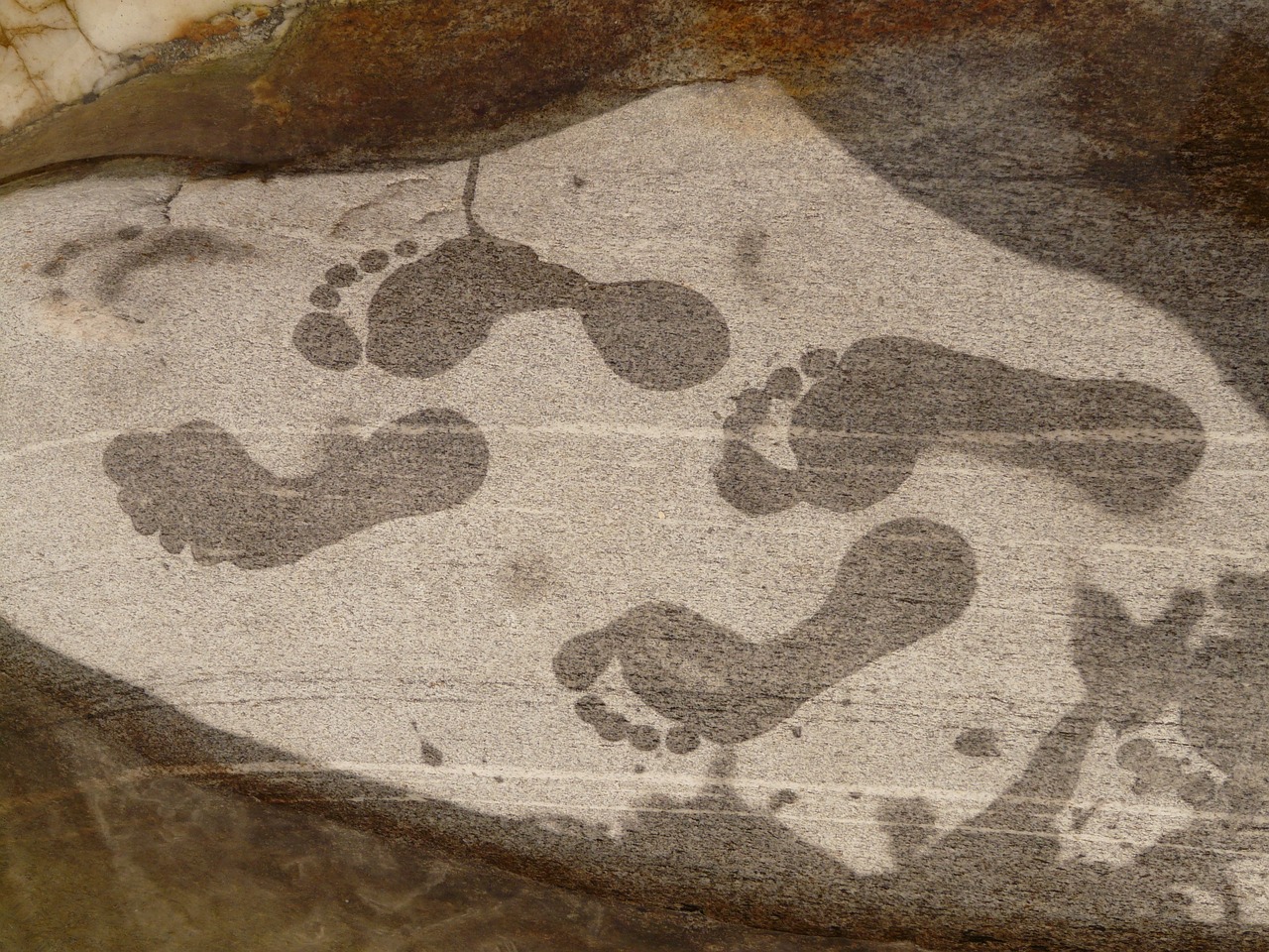 a close up of a rock with footprints on it, a cave painting, inspired by Henri Michaux, graffiti, phone wallpaper, pregnancy, tim hildebrant, shaded