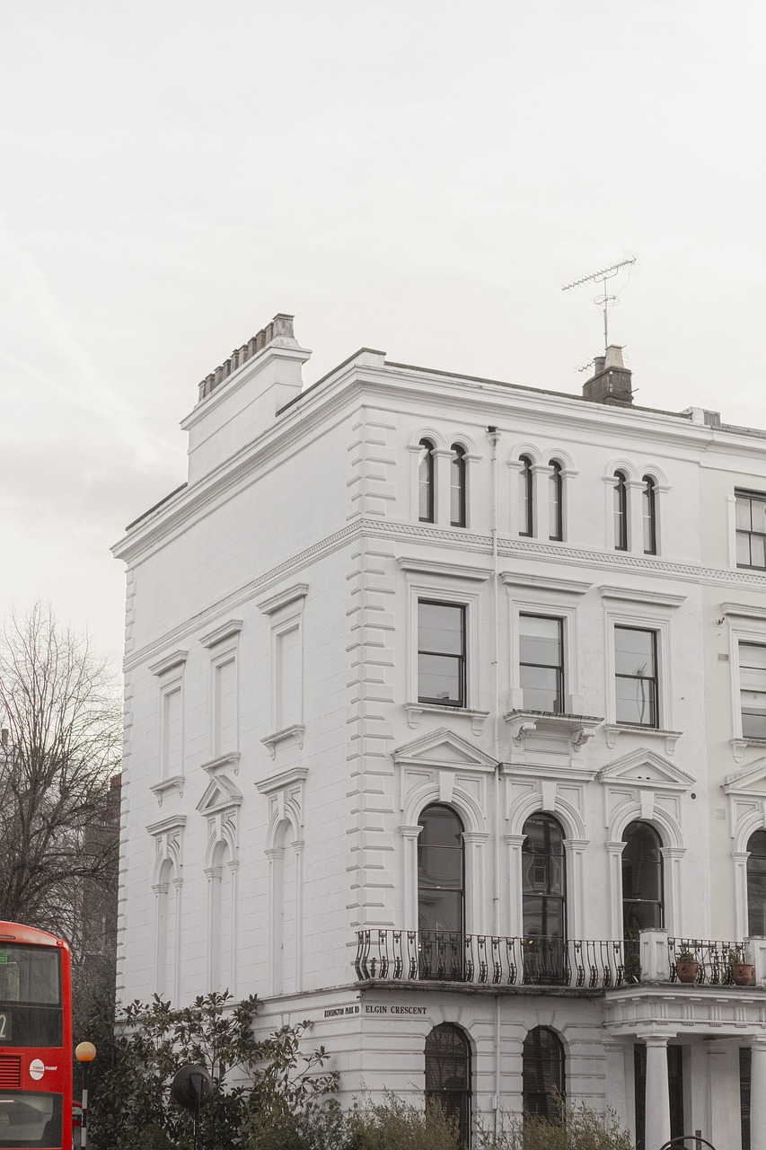 a red double decker bus driving past a large white building, a photo, inspired by Rachel Whiteread, unsplash, victorian house, all white render, shot on leica sl2, 4k high res
