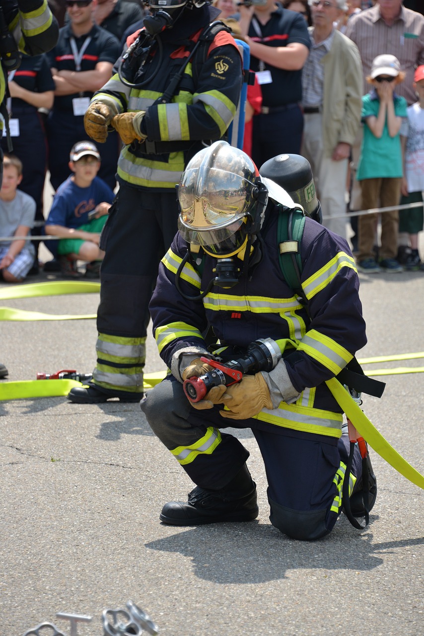 a firefighter kneeling on the ground with a hose, a photo, figuration libre, festival, helmet on, toward to the camera, pentagon
