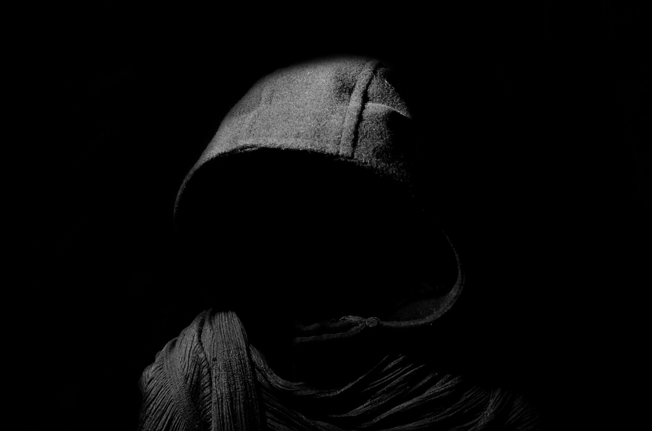 a black and white photo of a person in a hoodedie, inspired by Nicola Samori, unsplash, digital art, hooded figure, dark helmet, high quality photo, shadowy informant