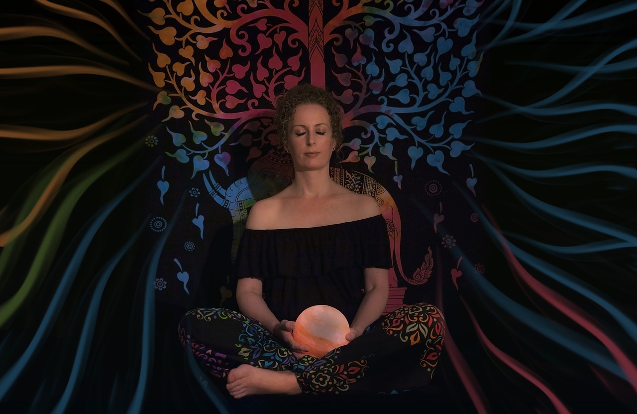 a woman is sitting in a meditation position, a portrait, by Barbara Balmer, pexels, digital art, tree of life inside the ball, black light, sigourney weaver, centered full body pose