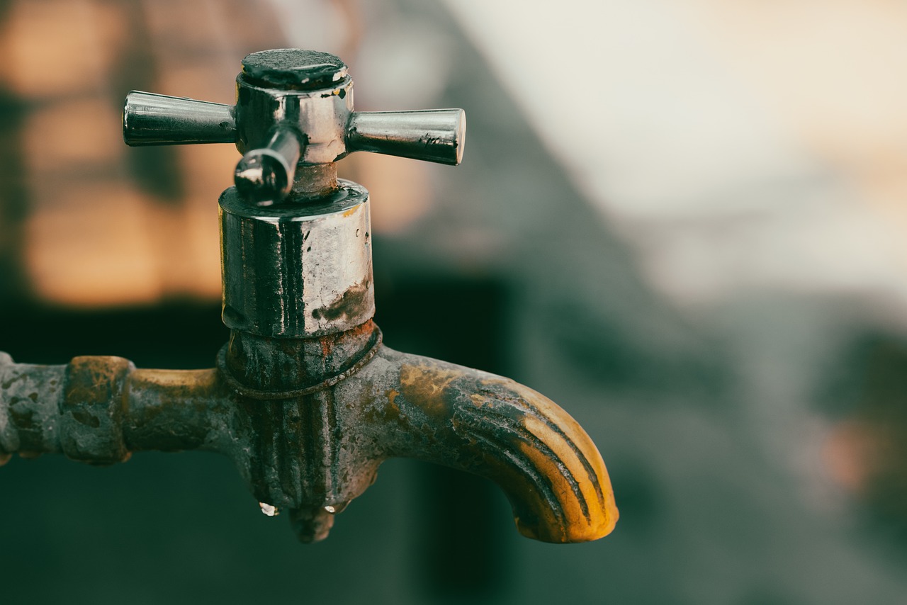 a close up of a water faucet with a building in the background, a tilt shift photo, renaissance, many rusty joints, vintage color, transparent background, rust background