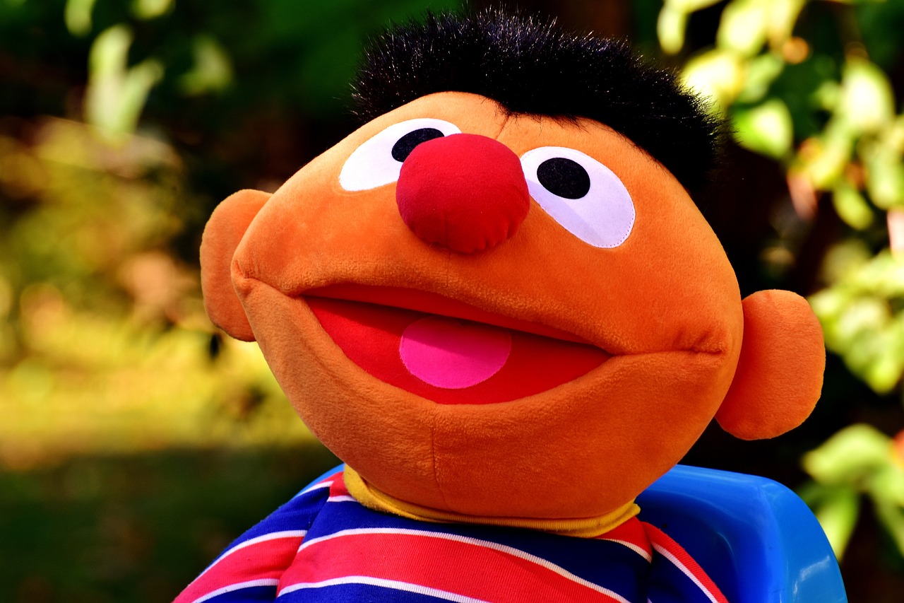 a close up of a stuffed animal on a chair, pexels, mr. bean depicted as a muppet, 188216907, japanese mascot, clown face