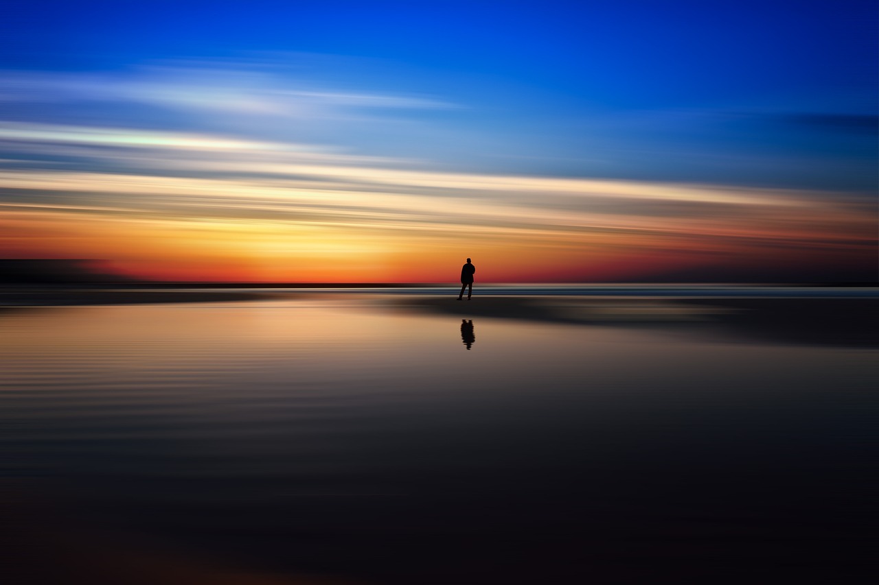 a person standing on a beach at sunset, a picture, by Holger Roed, minimalism, slow exposure hdr 8 k, infinite reflections, vivid deep colors, an abstract