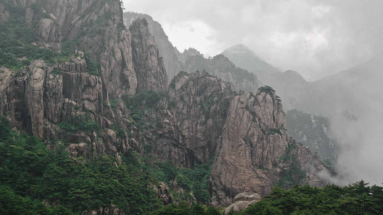 a herd of sheep standing on top of a lush green hillside, a detailed matte painting, by Ren Xiong, unsplash contest winner, the taoist temples of huangshan, with lots of dark grey rocks, telephoto long distance shot, traditional korean city