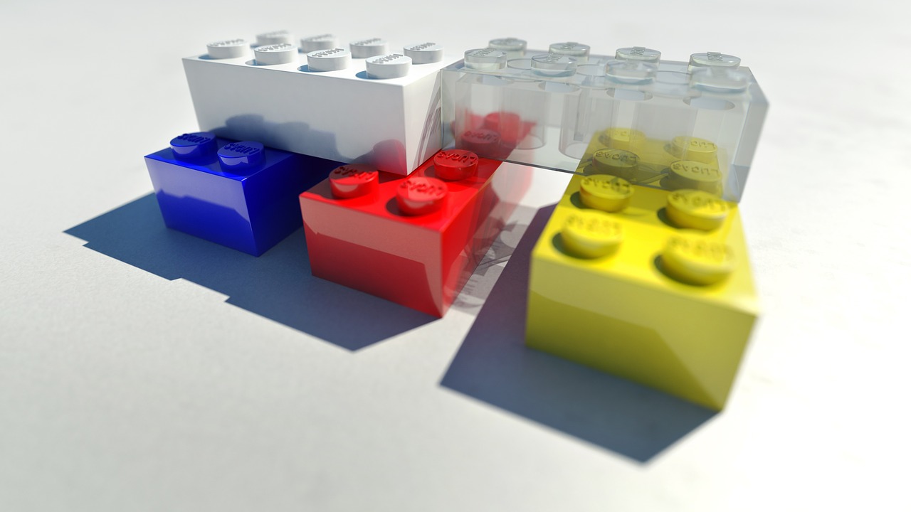 a group of lego blocks sitting on top of a table, a 3D render, flickr, transparent glass surfaces, primary colors, detail render, rendered in arnold engine