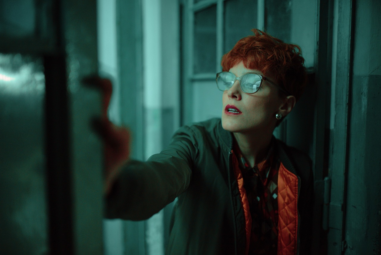 a woman with red hair wearing glasses and a tie, inspired by Ruth Deckard, atmospheric warm colorgrade, stood in a cell, vfx action shot, jean deville