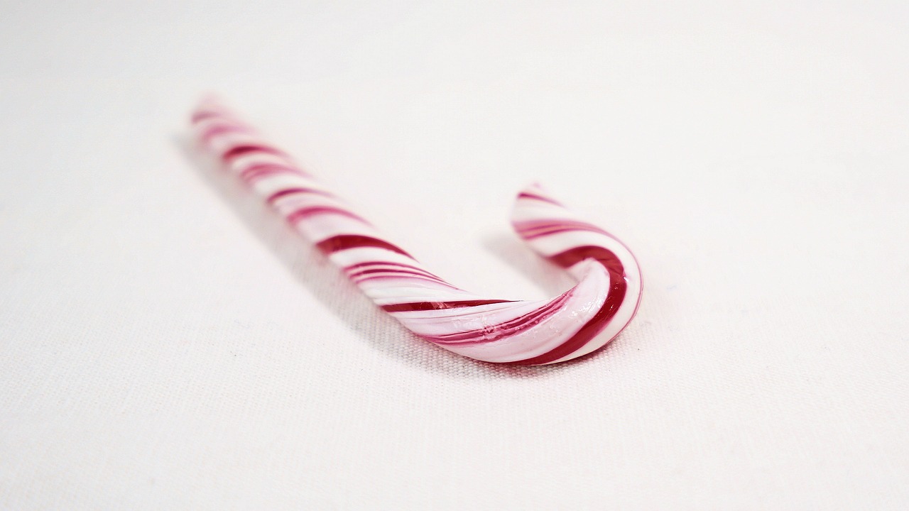 a close up of a candy cane on a white surface, by Shinji Aramaki, hurufiyya, 4k polymer clay food photography, pink, wikimedia commons, single long stick