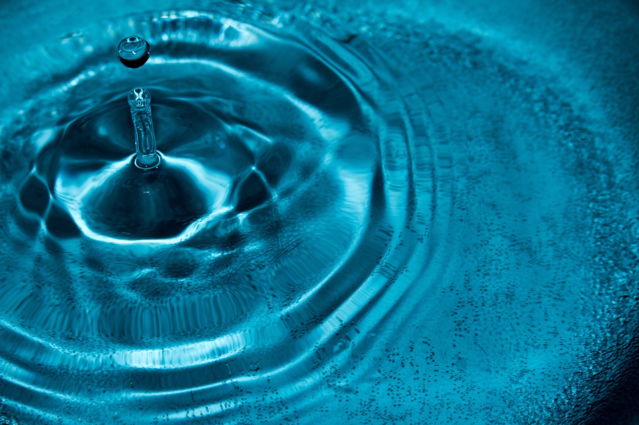 a close up of a water drop in a sink, inspired by Lucio Fontana, cymatics. auditory symbiogenesis, hyper detailed background, azure waves of water, floating in a powerful zen state