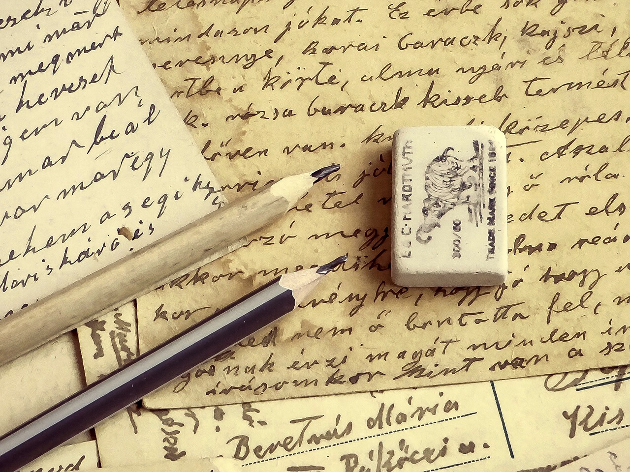 a couple of pencils sitting on top of a piece of paper, inspired by Władysław Podkowiński, old manuscript, writing a letter, vintage theme, header text”