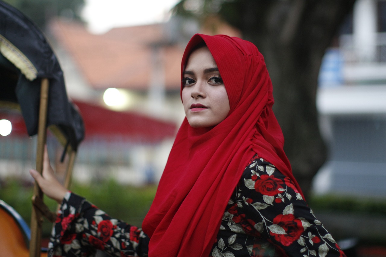 a woman in a red hijab holding an umbrella, by Basuki Abdullah, shutterstock, beauty girl, square, batik, black and red only