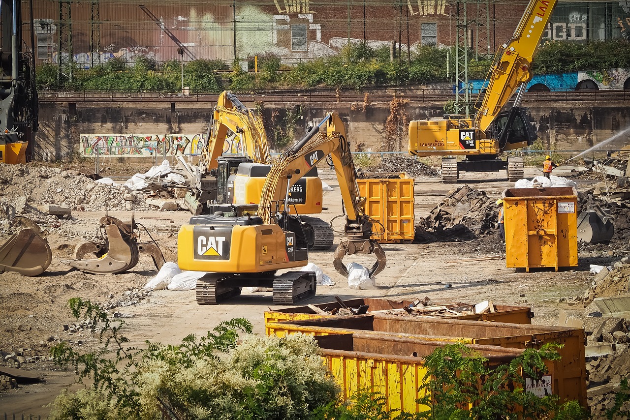 a group of construction equipment sitting on top of a dirt field, by Arnie Swekel, flickr, city destruction, industrial robotic cats, pittsburgh, dredged seabed