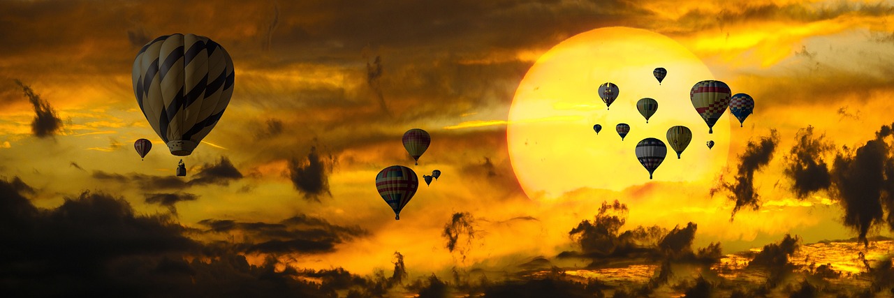 a group of hot air balloons flying in the sky, a picture, inspired by Igor Zenin, pixabay contest winner, large sun in sky, hazy sunset with dramatic clouds, asian sun, yellow