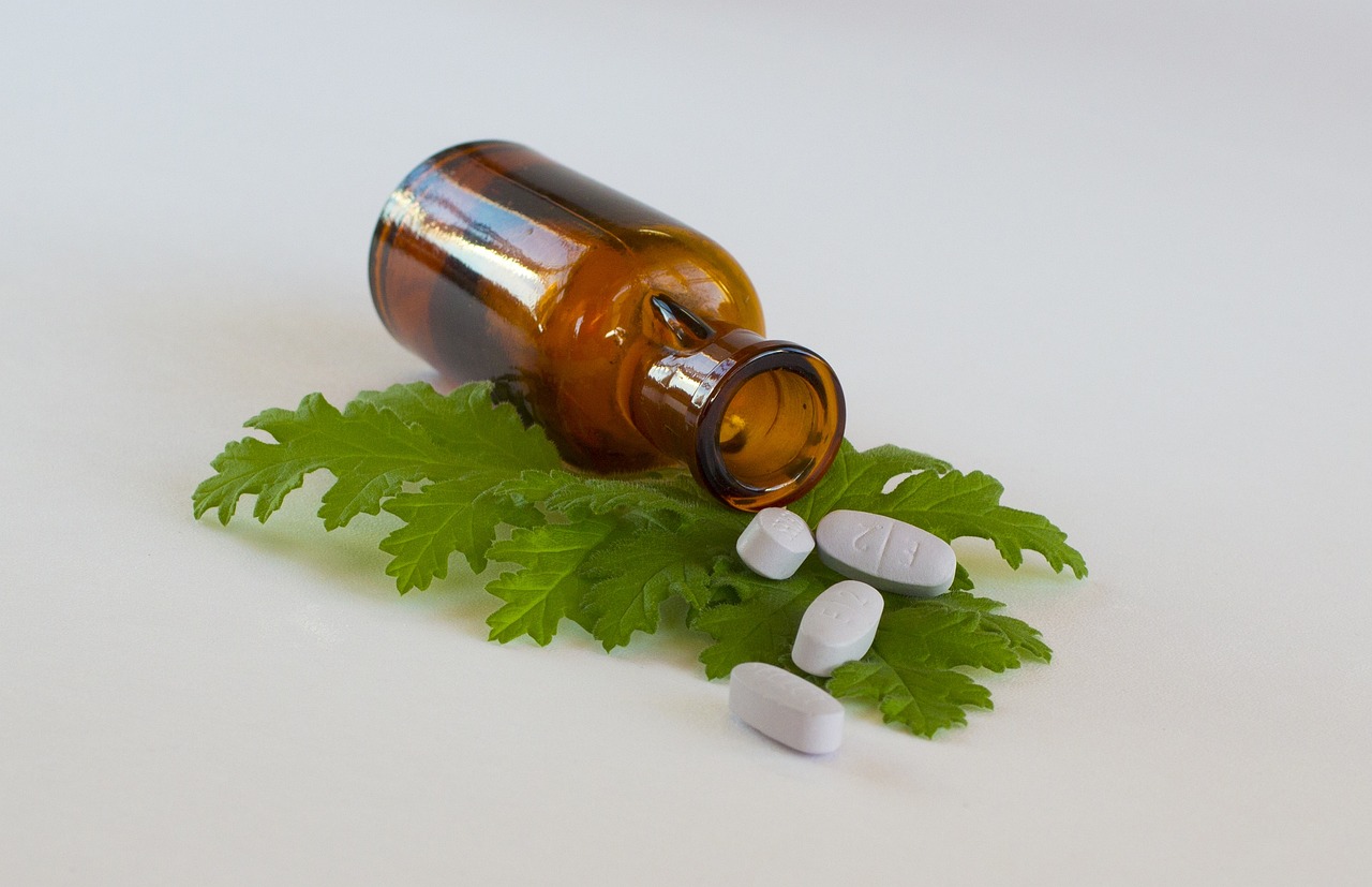 a bottle filled with pills sitting on top of a green leaf, a photo, by Mirko Rački, on a pale background, pestle, garnishment, fern