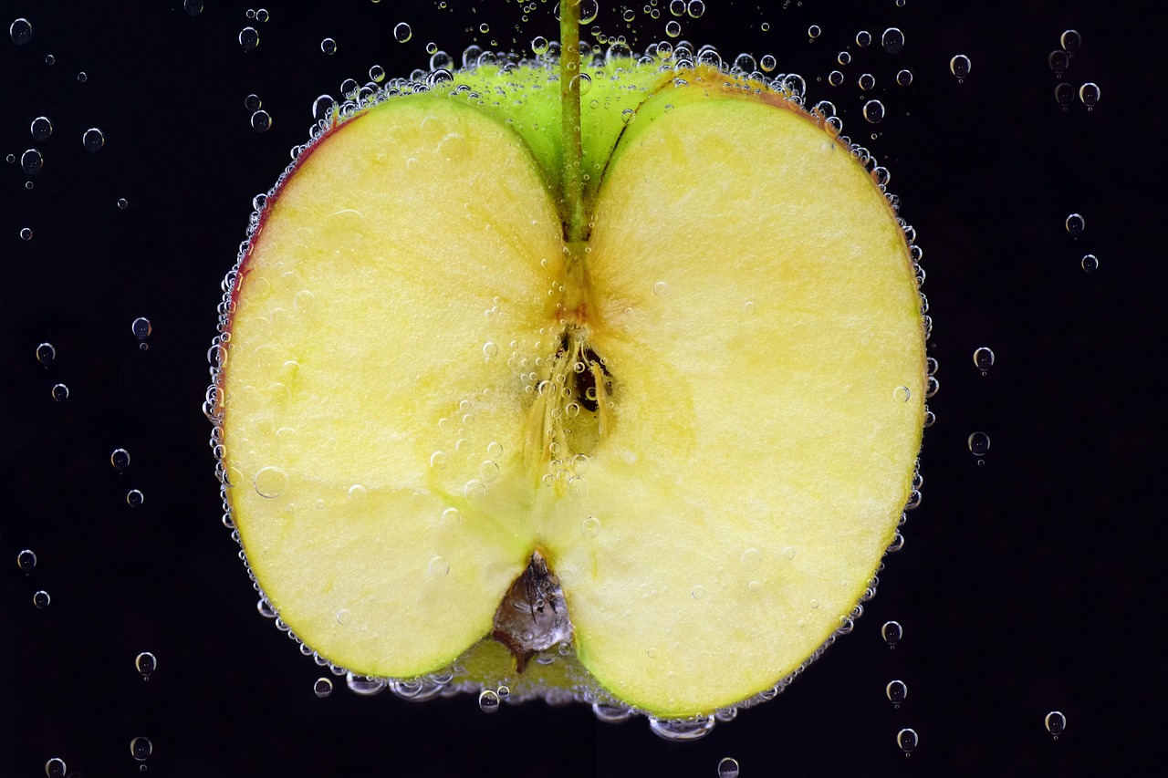 a close up of an apple sliced in half, a macro photograph, shutterstock, water bubbles, detailed zoom photo, stock photo