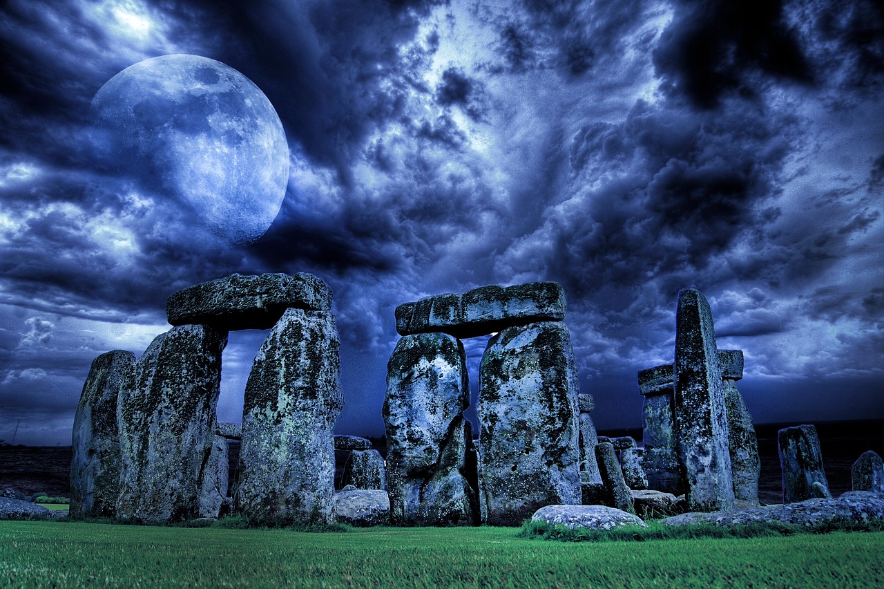 a group of stones sitting on top of a lush green field, by John Moonan, pixabay contest winner, surrealism, nighttime moonlit, stonehenge, shamanistic dark blue clothes, apocalyptic architecture