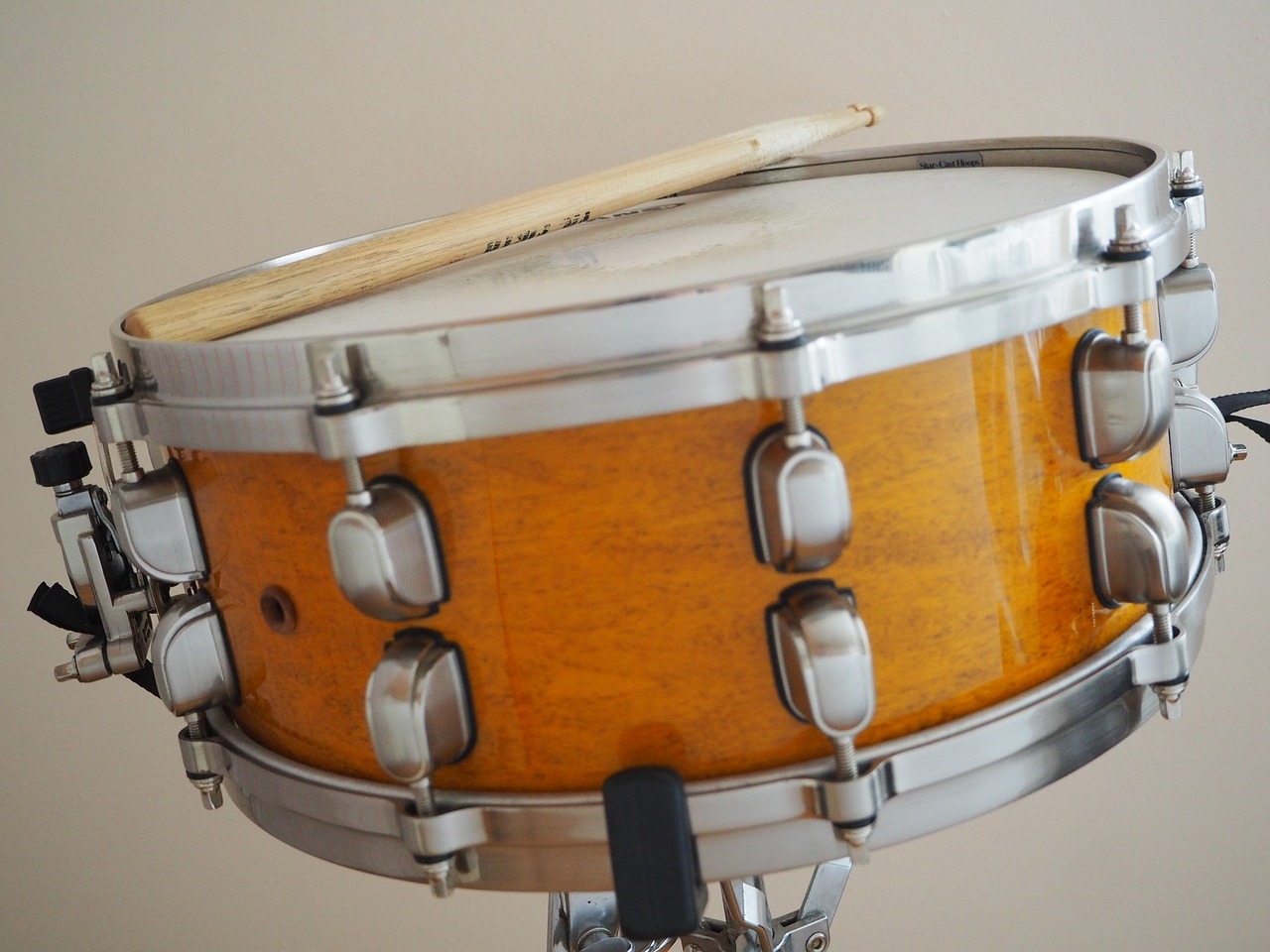 a drum with a wooden stick on top of it, by David Simpson, pixabay, shiny knobs, yellow, midcentury modern, 7 0 mm photo