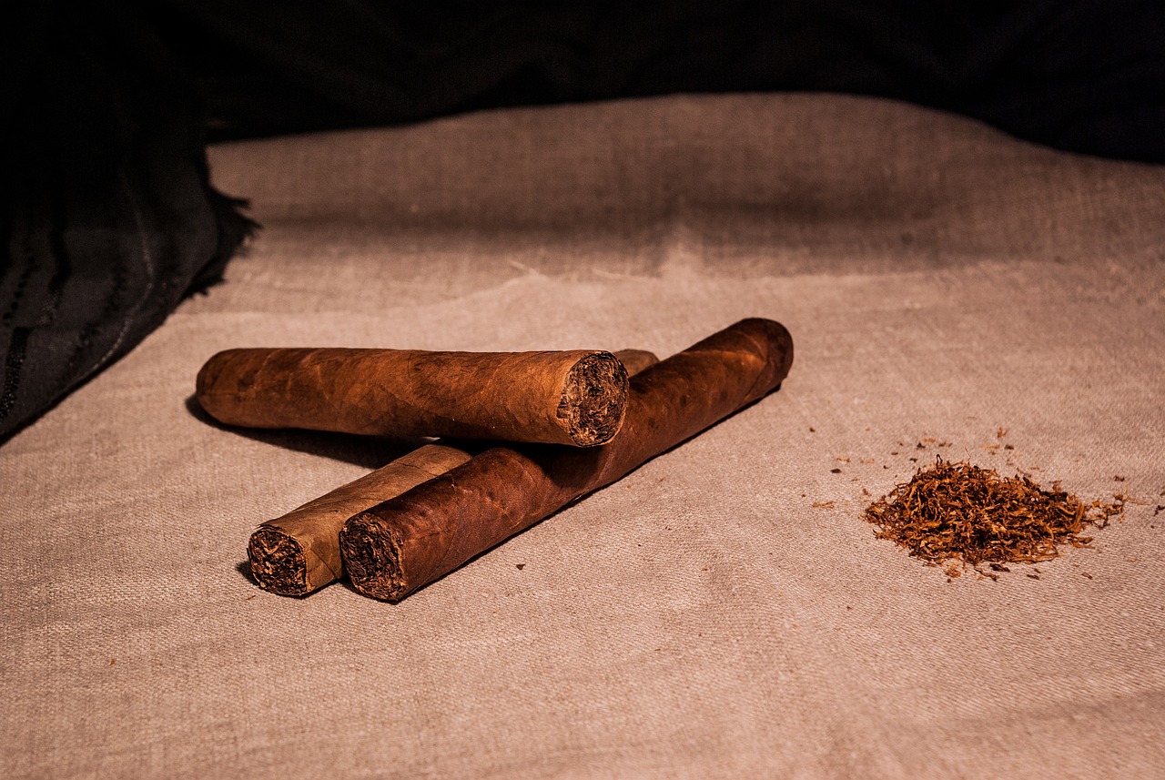 a couple of cigars sitting on top of a table, figuration libre, cinnamon, backdrop, rags, rule of three