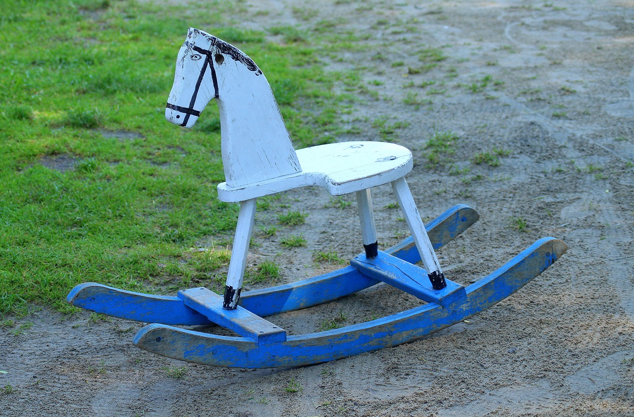 a wooden rocking horse sitting on top of a dirt road, pixabay, folk art, white and blue, 1952, hyperealistic photo, ebay photo
