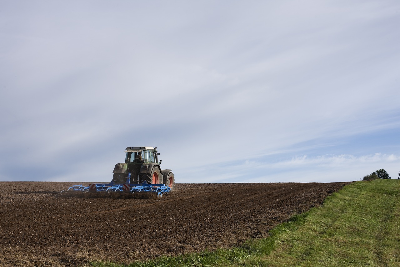 a tractor plowing a field on a cloudy day, a photo, by Matthias Stom, figuration libre, wide establishing shot, horizon view, high res photo, sweden