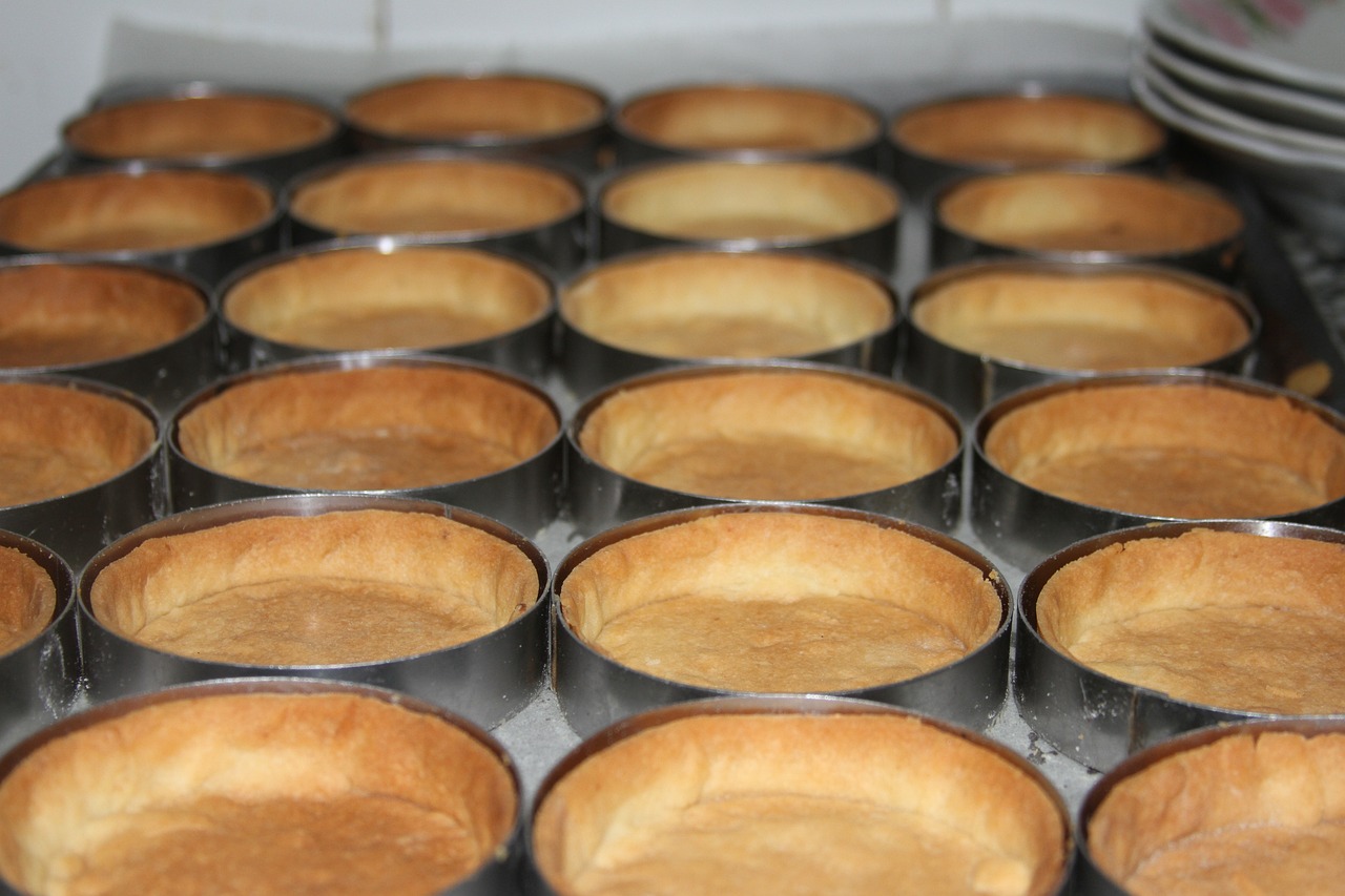 a pan filled with muffins sitting on top of a stove, hurufiyya, many golden layers, 8 0 mm photo, pie eyes, flan