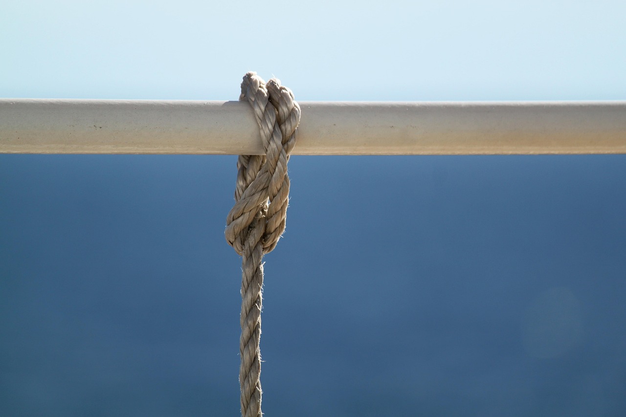 a close up of a rope on a boat, a picture, minimalism, mathematical interlocking, épaule devant pose, hanging, piping