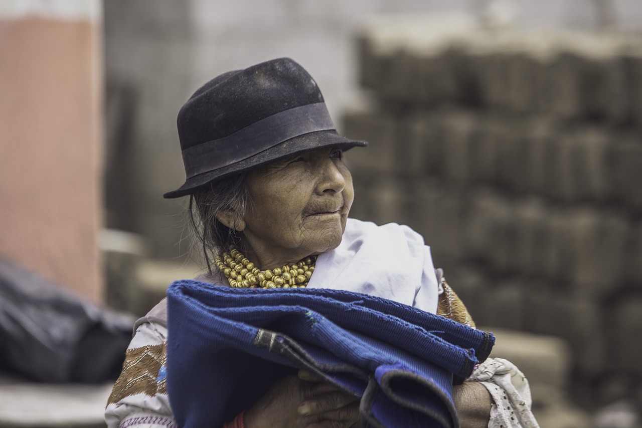 a close up of a person wearing a hat, by Matteo Pérez, pexels contest winner, quito school, covered with blanket, older woman, colombian, detailed surroundings