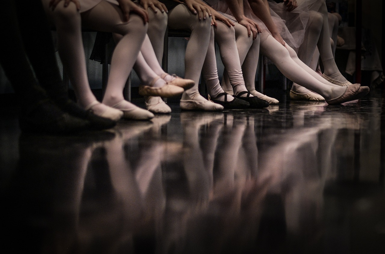 a group of ballerinas sitting next to each other, a picture, by Fabien Charuau, shutterstock, detailed reflections, photo taken with nikon d 7 5 0, in a row, dimly lit