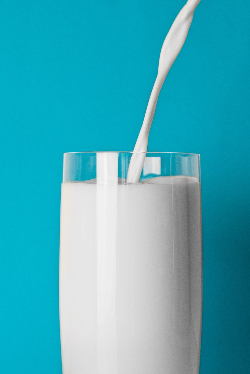 milk being poured into a glass on a blue background, by Juan O'Gorman, shutterstock, hyperrealism, background image, 1 9 7 0 s photo, farming, le corbusier