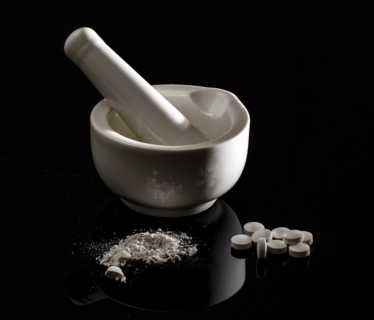 a mortar and some pills on a table, by Tom Carapic, flickr, in front of a black background, porcelain, mortar and pestle, modern high sharpness photo