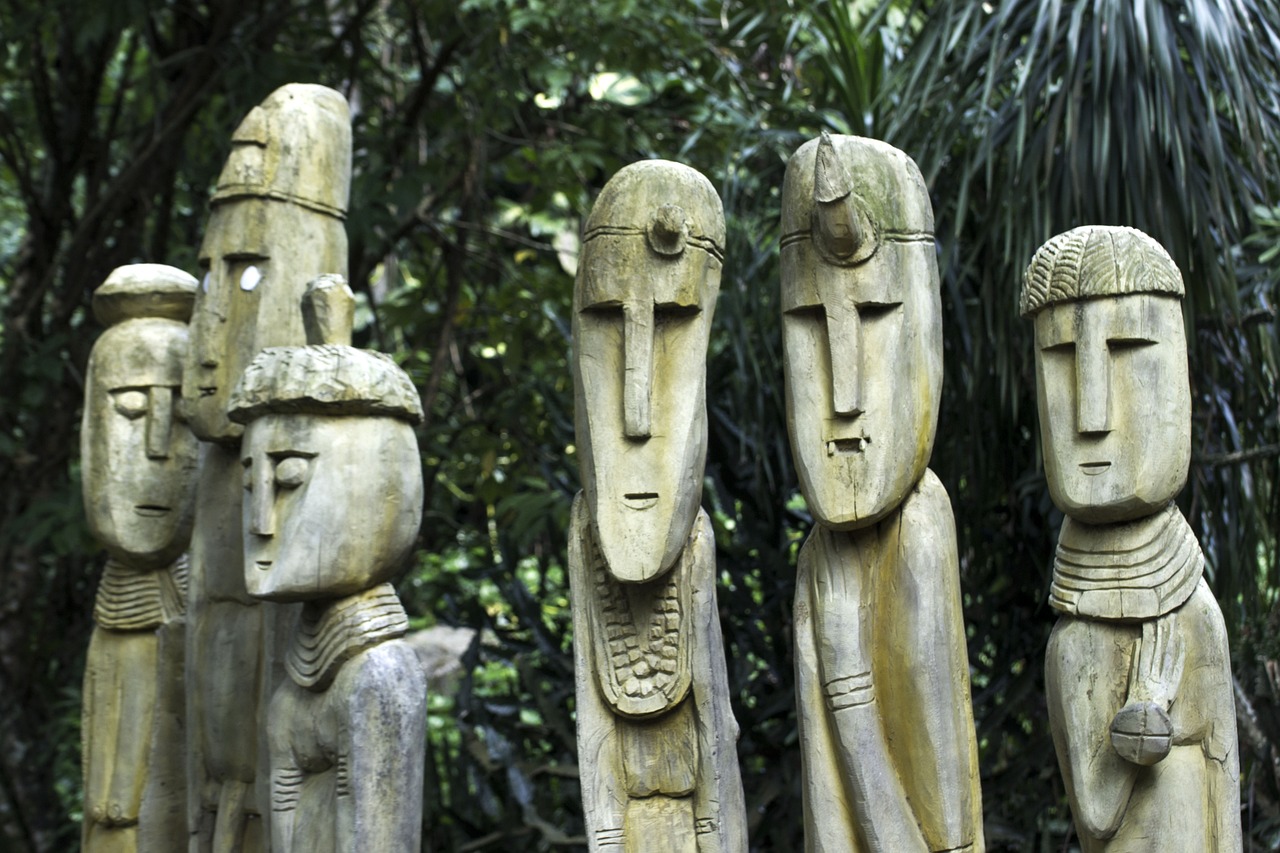a group of statues sitting on top of a lush green forest, inspired by Kogan Gengei, flickr, folk art, in the tropical wood, head details, sao paulo, maori ornament
