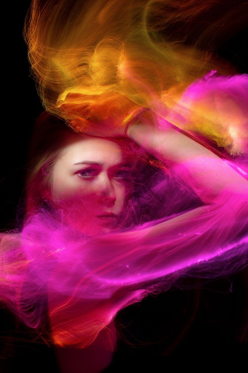 a woman with her hair blowing in the wind, a portrait, inspired by Arik Brauer, digital art, neon smoke, pink volumetric studio lighting, portrait of kate winslet, casting a multi colored spell