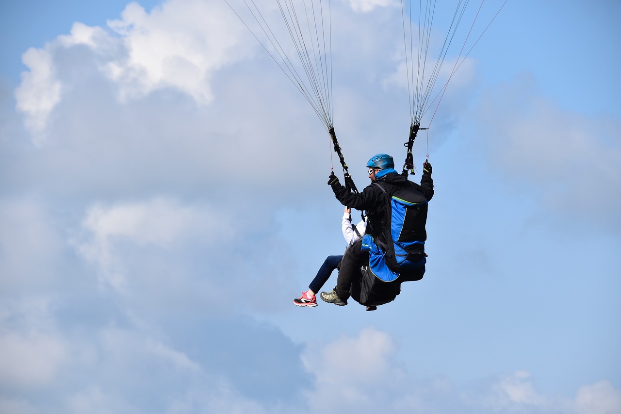 a man flying through the air while holding onto a parachute, a photo, by Frederik Vermehren, shutterstock, couple, photo taken from far away, spreading her wings, stock photo