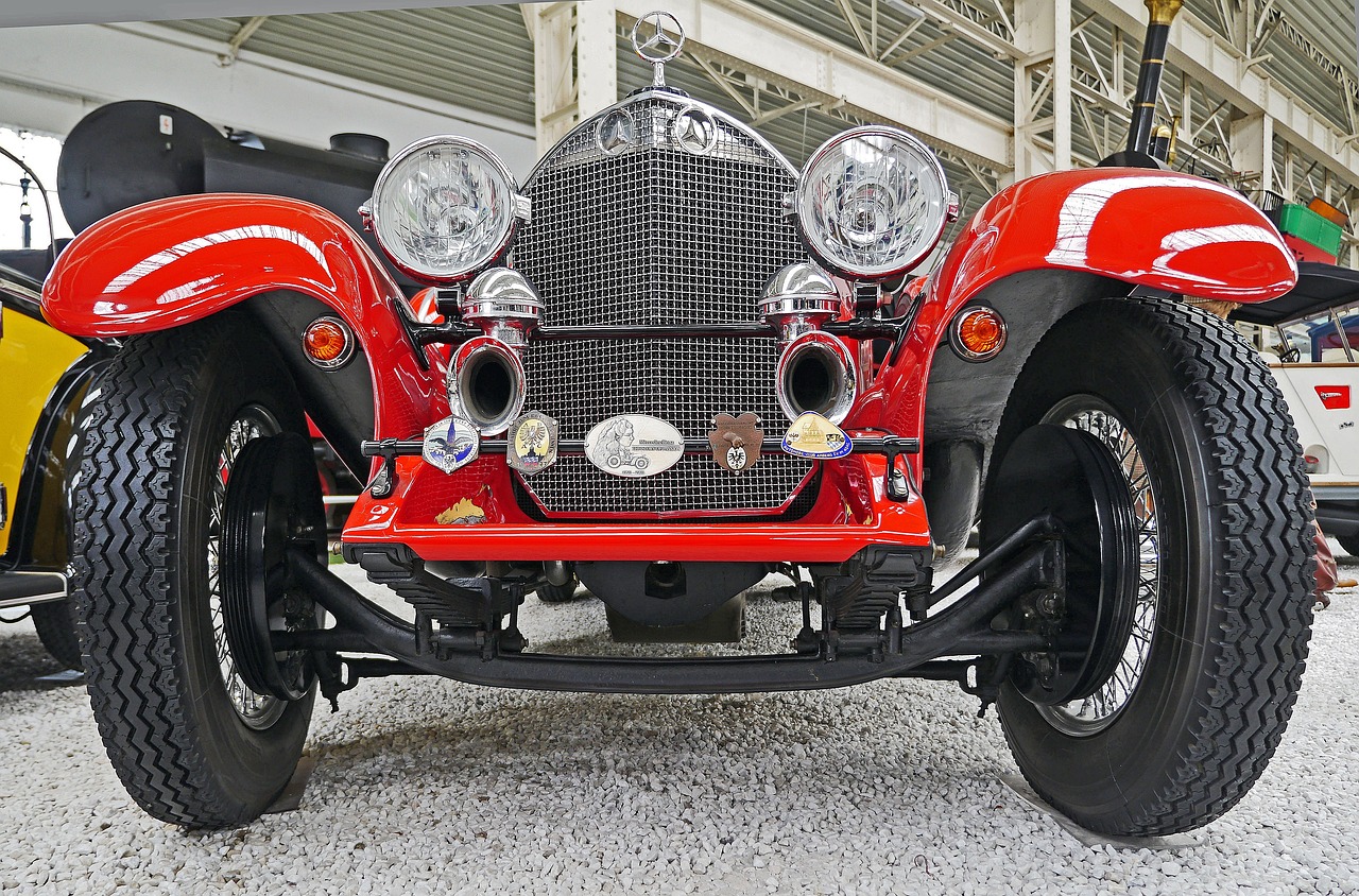 a red car is parked in a garage, by Leo Goetz, chitty chitty bang bang, closeup photo, extremely detailed frontal angle, panorama