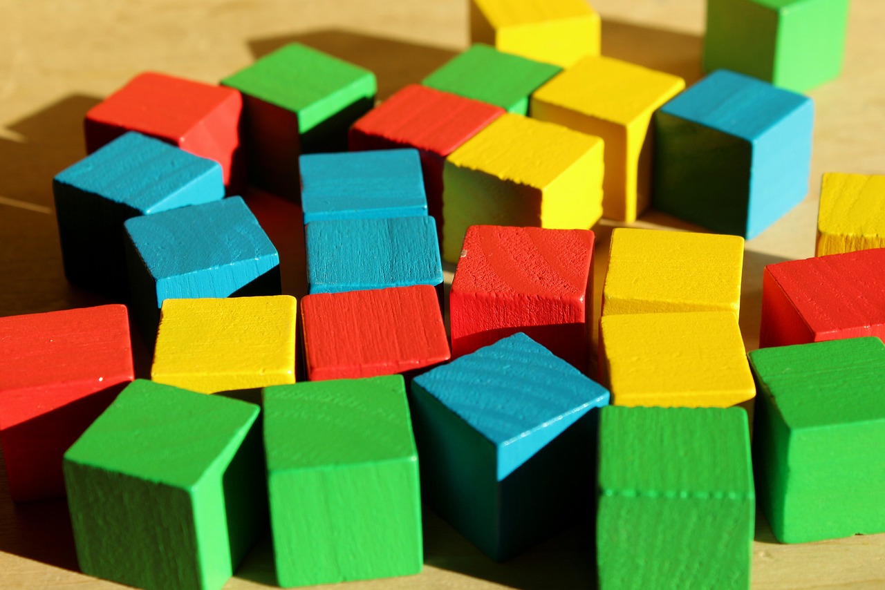 a pile of wooden blocks sitting on top of a table, a picture, pixabay, modular constructivism, primary colours, cube shaped, zoomed in, colored projections