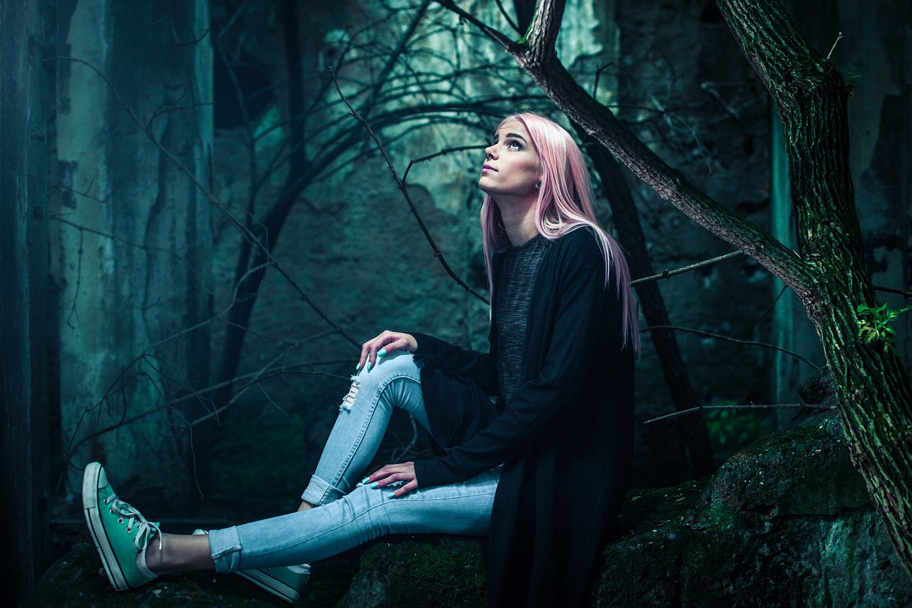 a woman with pink hair sitting on a rock in the woods, aestheticism, dark minimal outfit, grim fashion model looking up, deep lighting, wearing a dark shirt and jeans