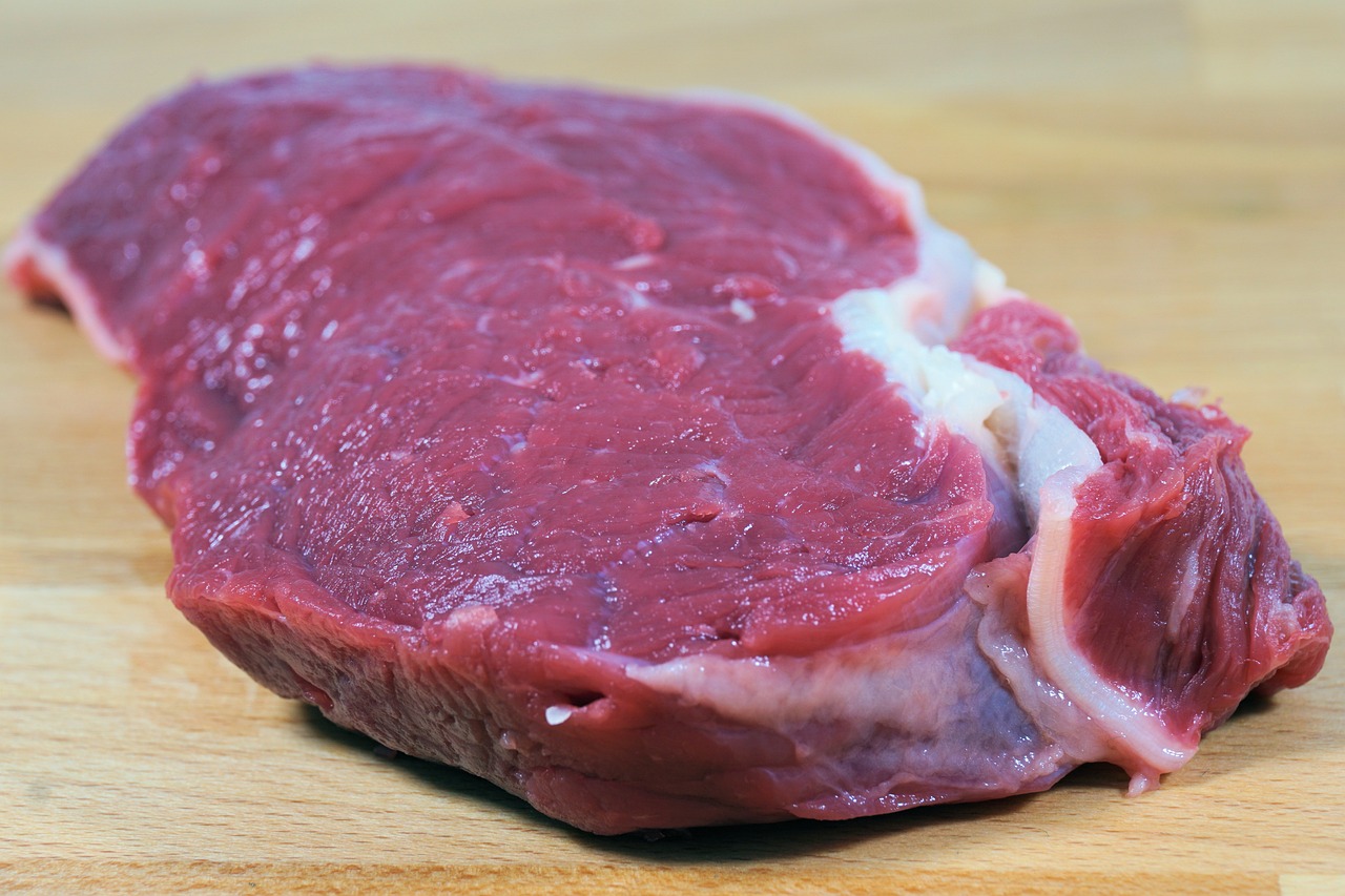 a piece of meat sitting on top of a wooden cutting board, a picture, shutterstock, half body photo, realistic footage, calf, older male