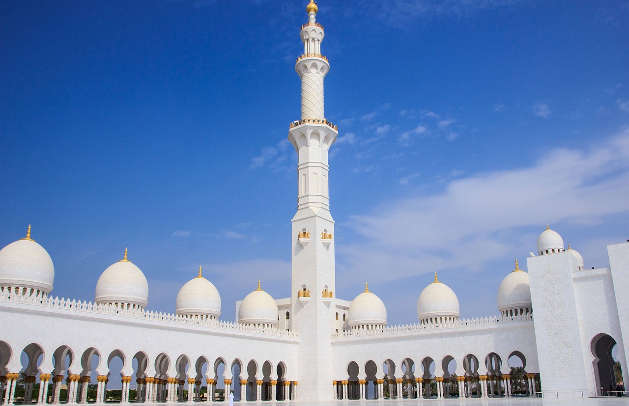 a large white building with a tall tower, inspired by Sheikh Hamdullah, shutterstock, arabesque, domes, beautiful day, ground level shot, black domes and spires