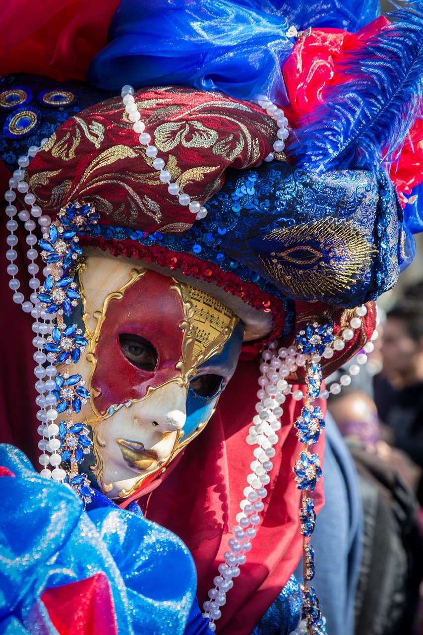 a close up of a person wearing a mask, by Carlo Martini, red blue and gold color scheme, carneval, innocent look. rich vivid colors, photo taken in 2018