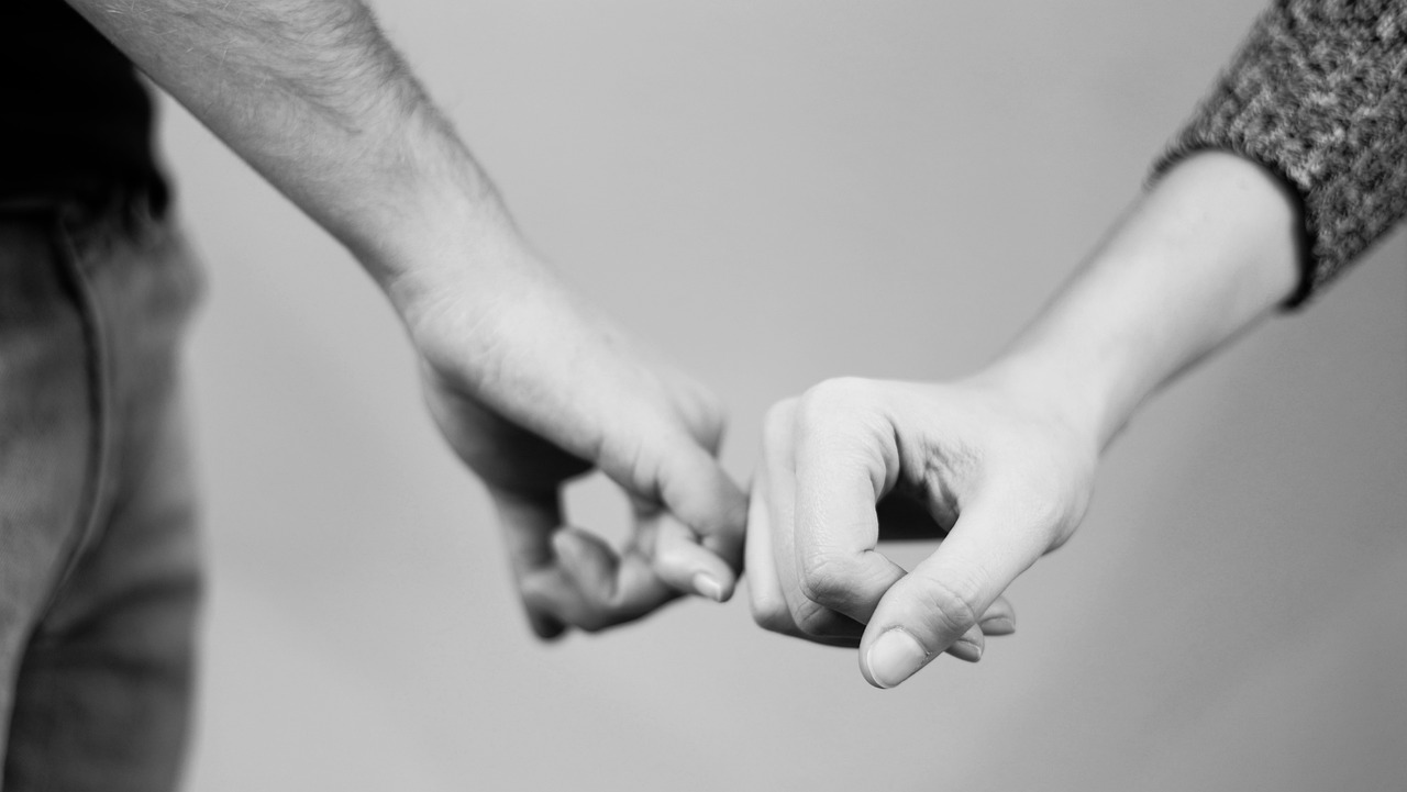 a black and white photo of two people holding hands, a black and white photo, close - up studio photo, fist training, connections, long distance photo