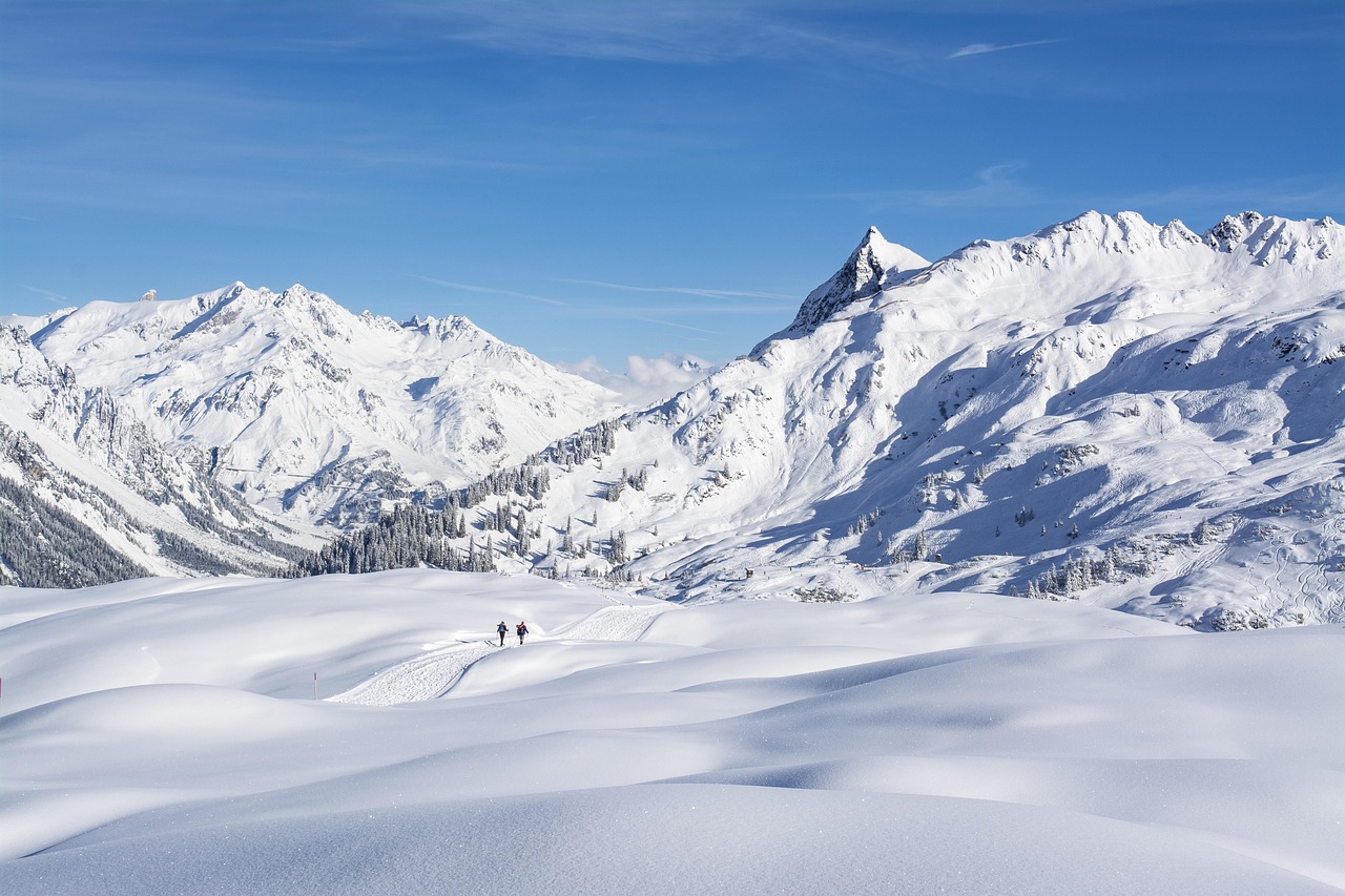 a couple of people riding skis down a snow covered slope, by Werner Andermatt, trending on pixabay, lush scenery, wide wide shot, jungian symbols of winter, in an epic valley