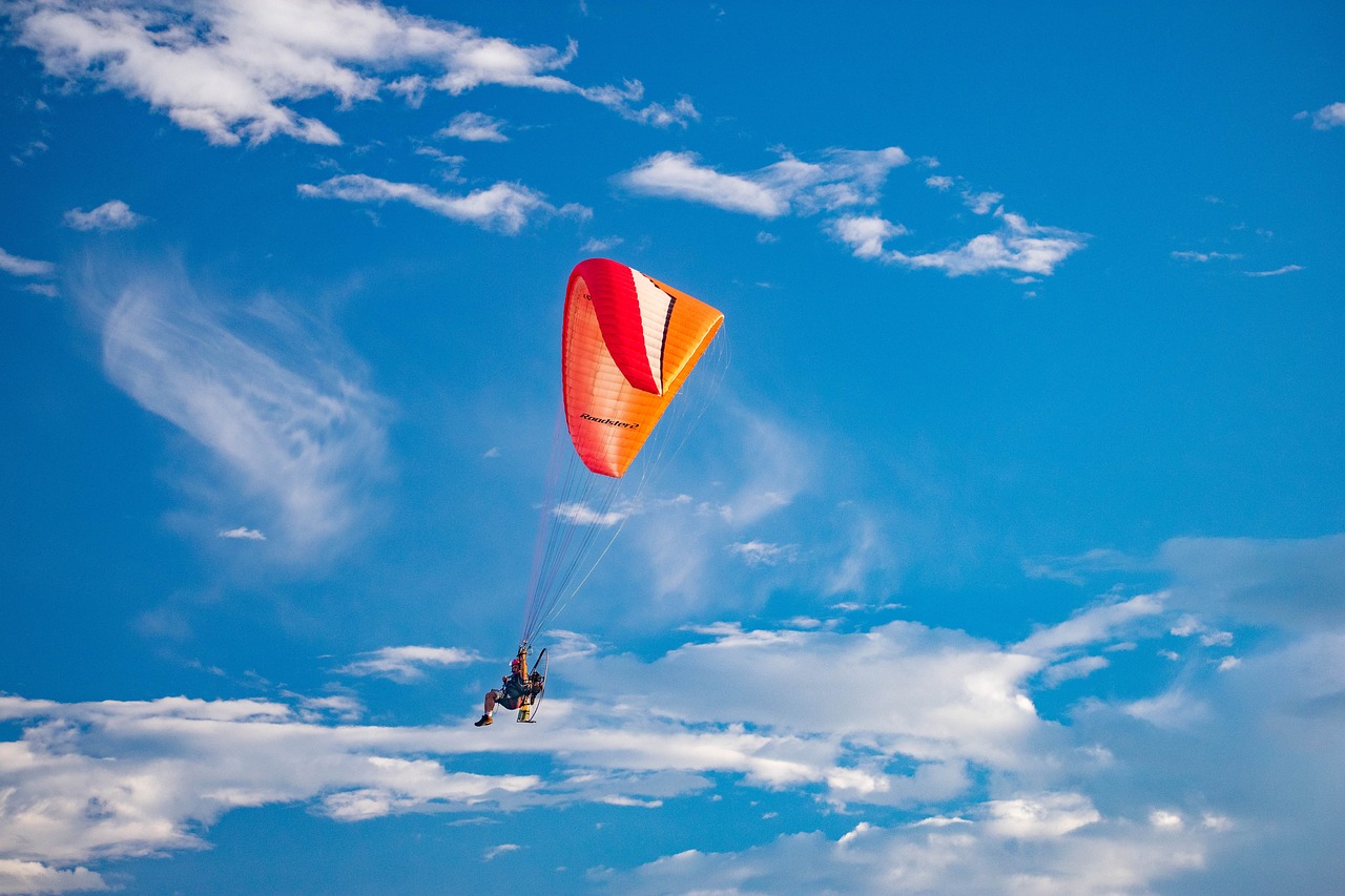 a person that is flying a kite in the sky, a picture, by Jan Rustem, shutterstock, parachutes, flying car, new mexico, red and orange colored