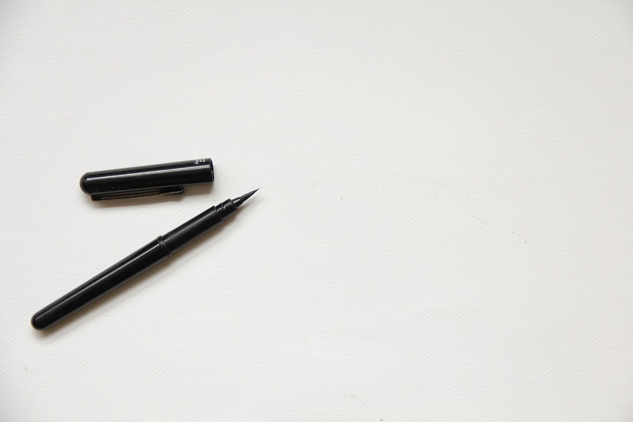 a black pen sitting on top of a white table, visual art, minimalist background, line brush, product introduction photo