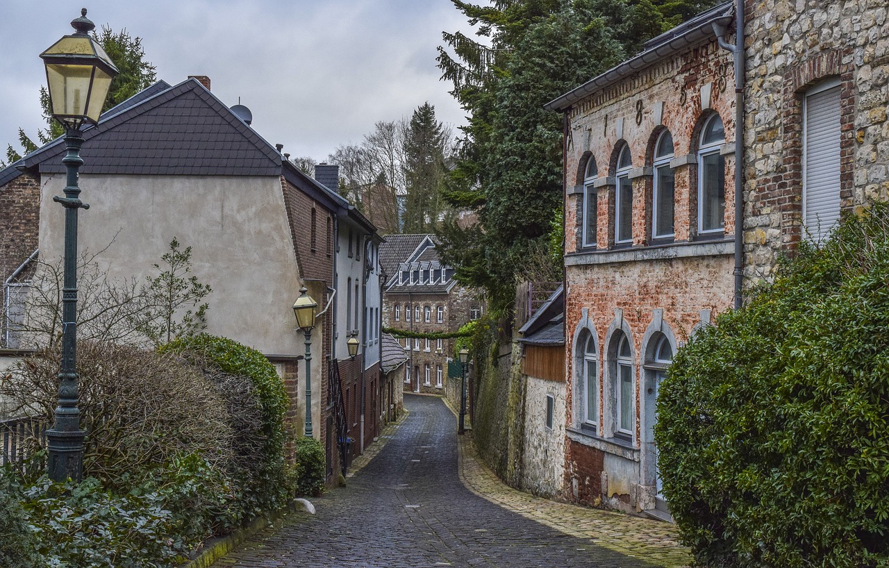 a cobblestone street in an old european village, a photo, by Karl Hagedorn, shutterstock, a ghetto in germany, detmold charles maurice, view from back, february)