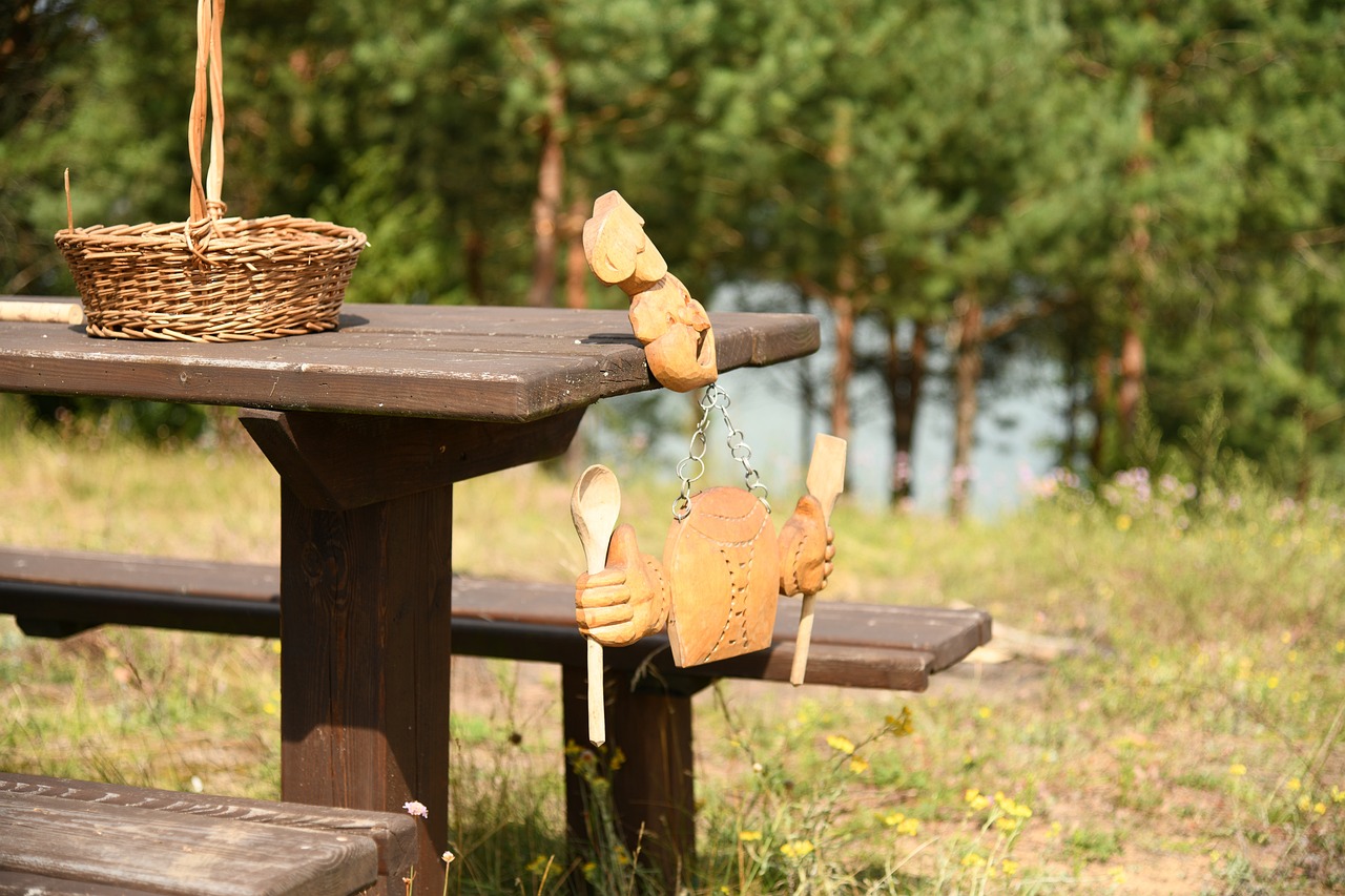 a wooden toy sitting on top of a picnic table, by Henryka Beyer, comfortable atmosphere, cutlery, lakeside, puppet